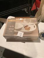 Photo of boxed CorningWare Etch 4-piece bakeware set showing white dishes with handles and lid, brand and set name on box top.