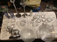 Lot overview showing glassware, candlesticks, decorative bowls, and elephant figurine.