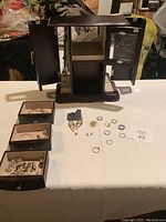 Full view showing jewelry box open with drawers removed and laid out with jewelry pieces on the table
