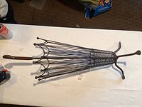 Side photo of umbrella stand showing full profile, metal ribs and wooden handle
