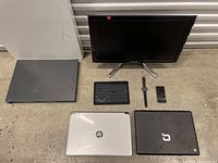 Photo showing all electronic items in the lot including monitors, laptops, tablets, smartwatch, and smartphone