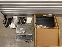 Lot contents showing Dell monitor in box and accessories including power adapter, cables, manual, keyboard.