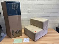 Photo showing new 2 step Zinus pet foam stairs in beige along with original box and instruction sheets.