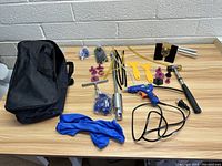 Image showing entire dent puller kit including hot glue gun, slide hammer, dent lifter tool, pulling tabs, scrapers, glue sticks, tubes, cloth, and storage bag.