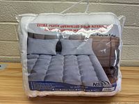 Front facing image of packaged mattress topper showing product name, image of topper on mattress and brand NSS.