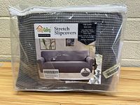Packaging of light gray textured stretch slipcover labeled Easy Going Stretch Slipcovers for oversized sofa with product details.