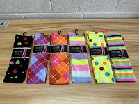 Photo showing 6 pairs of colorful thigh-high socks laid flat featuring hearts, argyle, stripes, and polka dots patterns.