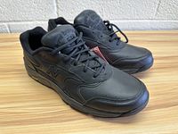 Pair of black men's New Balance walking shoes, size 9.5, shown from front-left angle on wooden surface.