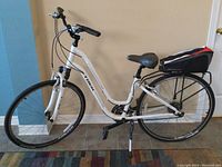 Full side view of white Trek Verve 3 step-thru bicycle showing frame, fork, wheels, saddle, rack and bag