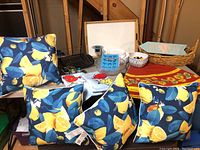 Photo showing four lemon-patterned blue patio cushions, assorted decorative dishes, and table cloths on display.