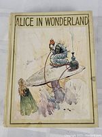 Front cover showing the color illustration of Alice and the Caterpillar on a mushroom, with the title 'ALICE IN WONDERLAND' at the top.