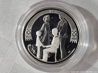 Reverse of the coin depicting a family of four figures in traditional clothing, holding hands and facing each other with decorative elements in the background, shown in reflective proof condition