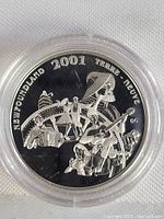 Close-up front view of the 2001 Newfoundland Silver Half Dollar Coin in a clear protective capsule showing detailed embossed design of musicians and dancers.