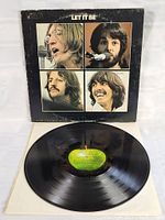 Front of the Let It Be album cover with photos of the four Beatles members and the vinyl LP shown below it.