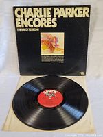 Front cover of Charlie Parker Encores The Savoy Sessions LP showing title text and abstract artwork with visible wear and scuffing.