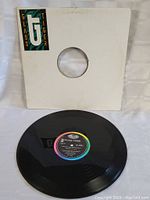 White record sleeve with glass tiger logo sticker at top left and black vinyl record with colorful label with album details and Capitol Records branding.