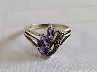 Front and slightly angled view of the sterling silver ring showcasing the three marquise amethyst stones and split shank design.