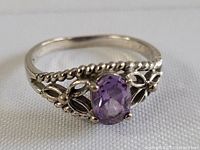 Front angled view of silver amethyst ring showing stone and band design