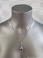 Full view of the necklace with pendant on a mannequin neck showing length and drape.