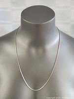 Front view of sterling silver box chain necklace displayed on a mannequin bust, showing length and shine.