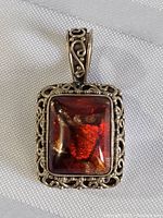 Front view showing rectangular red cabochon in silver filigree frame