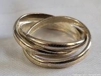 Close-up image of the sterling silver puzzle ring, showing the interlocking design with three bands in good condition.
