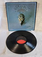 Vinyl record partially removed from sleeve showing label and condition of record surface.