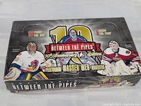 Closed box of 1991-92 Between the Pipes 10th Anniversary Edition goalie hockey cards featuring artwork of Malcolm Subban, Braden Holtby, and a center goalie.