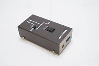 Top view of the rectangular black metal device showing Mitutoyo brand, data switch button, and schematic print.