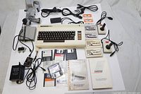 Full layout of Commodore VIC-20 computer with joysticks, game cartridges, floppy disks, cassette tapes and printed manuals