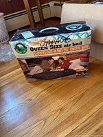 Original box of Intex Queen Size Air Bed showing product name, built-in pump feature, and people using the mattress.