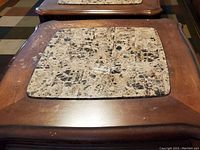 Top-down photo of wooden end table showing the stone insert centered on the tabletop. Surface shows visible scratches and watermarks.