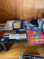 Photo of assorted wallets, key holder, high fashion ribbon and other accessories arranged on dark surface