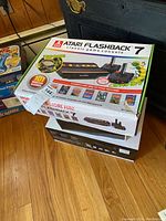Boxes of Atari Flashback 7 console showing packaging and features including 101 games and wireless controllers