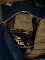 Blue bag open showing Coz-e heating blanket in packaging and other textile items inside