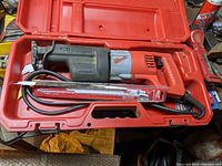 Milwaukee reciprocating saw with spare blades inside red Milwaukee carrying case