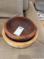 Two wooden bowls stacked, showing the lighter cherry wood bowl on the bottom and the smaller darker walnut bowl on top.