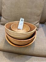 Four stacked wooden bowls, showing varying sizes and natural wood grain on fabric surface