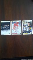 Three hockey cards featuring Wayne Gretzky, Mario Lemieux, and Sergei Fedorov laid out on a wood surface to show front designs and condition