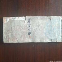 Front cover of the antique Chinese pattern design book, showing wear and tears, with Chinese characters on the cover.