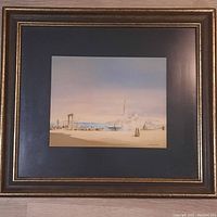 Full view of framed watercolour painting showing coastal scene under pastel sky with boats and figures, in wooden frame with gold trim.