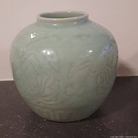 Front view of the bulbous celadon vase showing its rounded shape and subtle decoration.