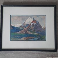 Front view of framed vintage Rocky Mountain watercolour painting, showing detailed mountain scene and black frame.
