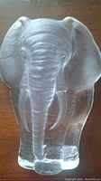 Full front view of crystal elephant on wooden surface