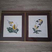 Two framed serigraph prints by Glen Rabena, featuring stylized animal and nature designs with brown mats and gold thin frames.