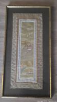 Full view of the framed silk embroidery showing the entire artwork with border and frame.