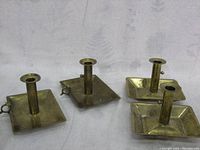 Four vintage brass candlesticks with square bases and regulator mechanisms to bring candles up or down, two marked Denmark.