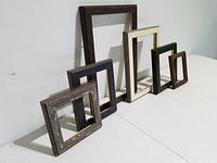 Six small to medium wooden picture frames arranged side by side, showing their colors and sizes.