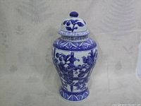 Full view of the large blue and white ginger jar showing floral and fruit patterns.