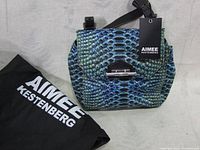 Front view of the Aimee Kestenberg bag with visible brand tag and accompanying dust bag.